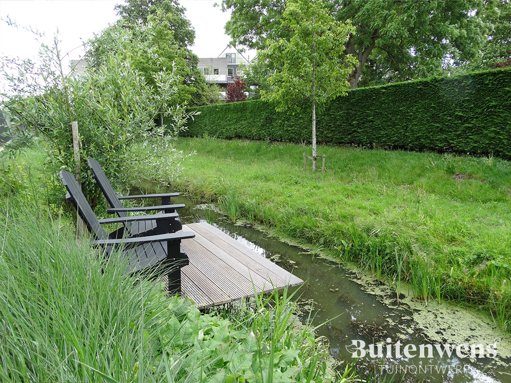 Buitenwens-Tuinontwerp-Heemskerk-Vijvertuin-Halfweg-met-zitje-aan-het-water