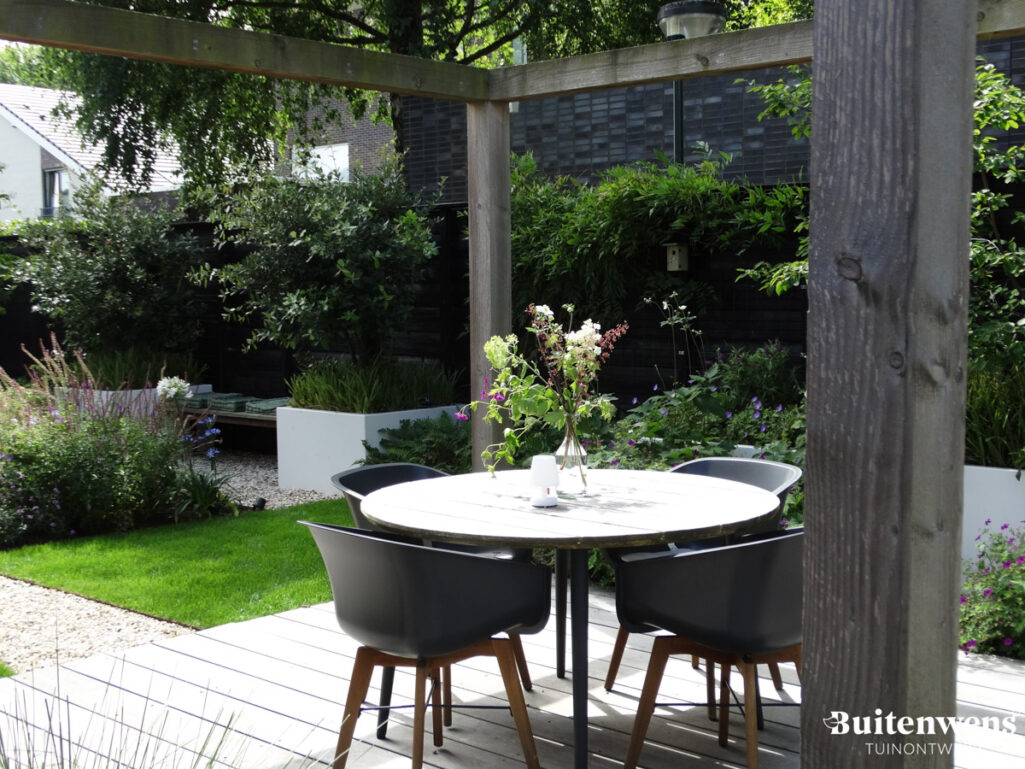 Buitenwens Tuinontwerp Heemkserk Moderne Leeftuin Heiloo met ronde eetset onder pergola